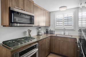 Kitchen featuring appliances with stainless steel finishes, light wood-type flooring, and modern cabinets