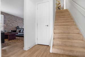 Stairs with brick wall and wood finished floors