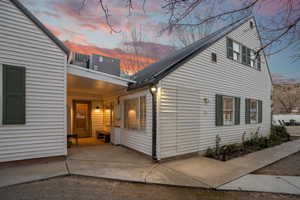 View of side of property with a metal roof and a patio area