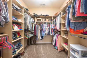 Walk in closet with light carpet