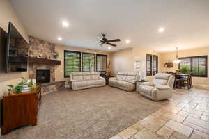 Living area with stone tile floors, a fireplace, recessed lighting, and ceiling fan