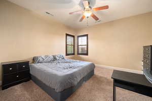 Carpeted bedroom with baseboards and a ceiling fan