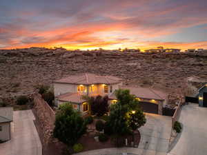 View of front facade with concrete driveway, a tile roof, stucco siding, and an attached garage
