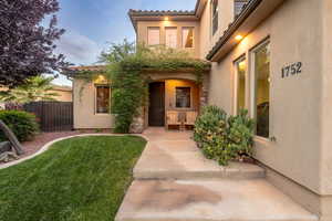 View of exterior entry with stucco siding and covered porch