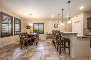 Dining area featuring recessed lighting and stone tile floors