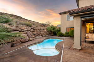 View of swimming pool with a patio area and a pool with connected hot tub