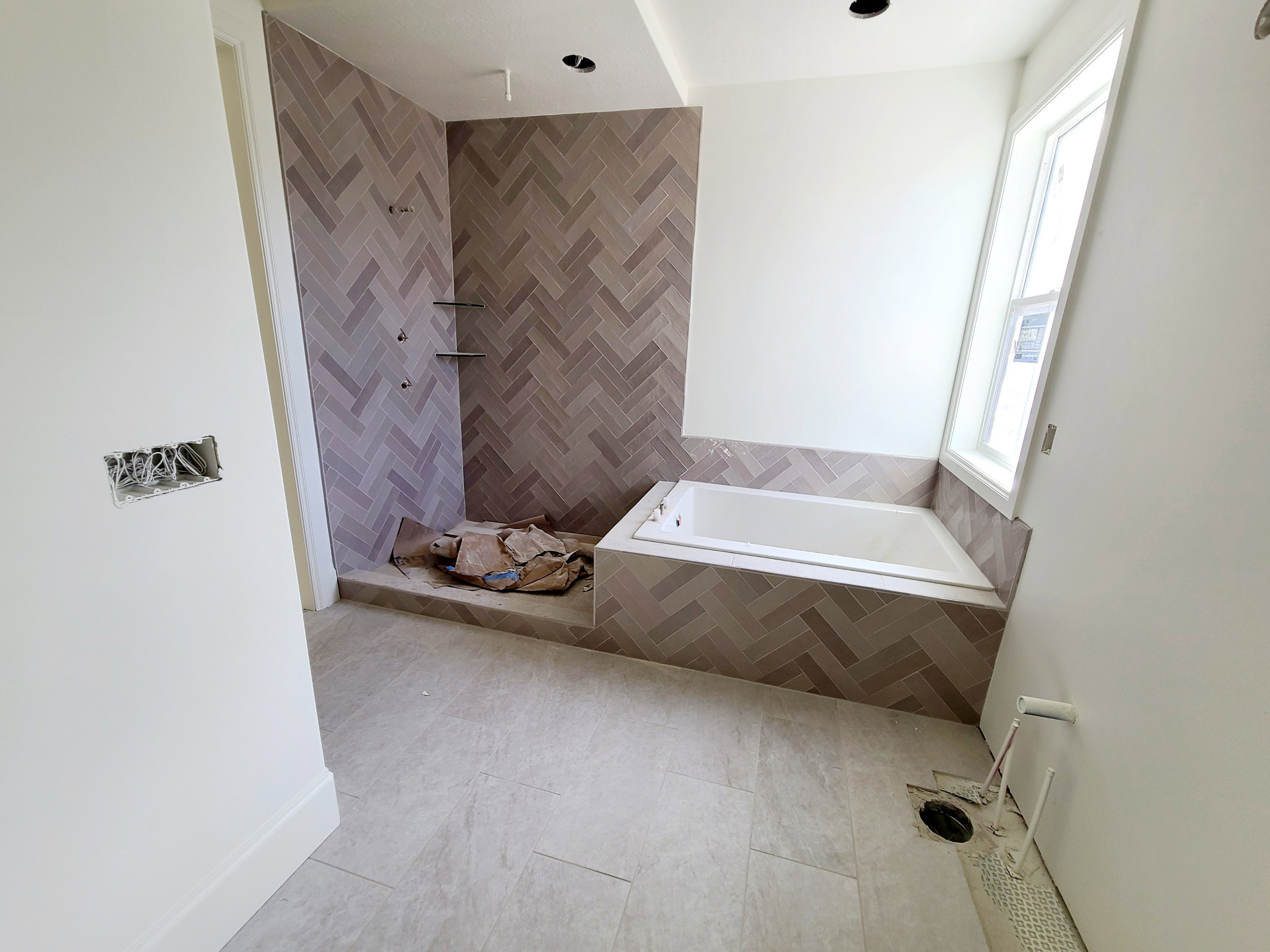 Bathroom featuring a bath, tiled shower, and tile walls
