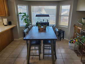 Dining space featuring light tile patterned floors and baseboards