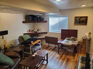 Living room with a textured ceiling and wood finished floors
