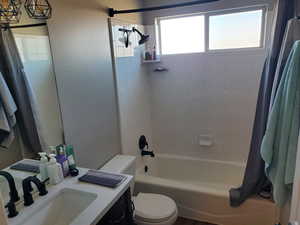 Bathroom featuring shower / bathtub combination with curtain and vanity