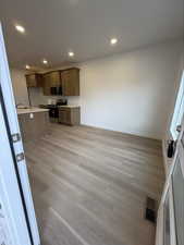 Kitchen with appliances with stainless steel finishes, light countertops, light wood-style floors, recessed lighting, and brown cabinetry