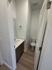 Half bath with vanity and dark wood finished floors