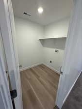 Washroom with dark wood-style floors, washer hookup, and electric dryer hookup