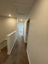 Corridor featuring an upstairs landing, dark carpet, and recessed lighting