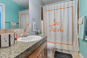 Full bath with vanity, shower / bath combination with curtain, and decorative backsplash