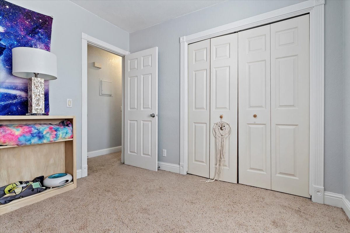Second Bedroom with light carpet and a closet