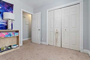 Second Bedroom with light carpet and a closet