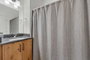 Bathroom with a shower with curtain and vanity