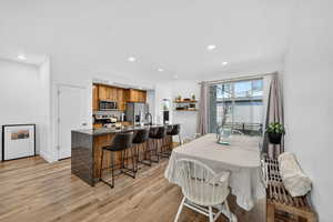 Dining area with light wood-style flooring and recessed lighting