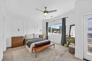 Carpeted bedroom featuring a decorative wall and ceiling fan