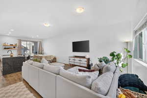 Living room with light wood-style flooring and recessed lighting