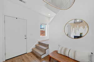 Foyer featuring light wood finished floors, stairs, and recessed lighting
