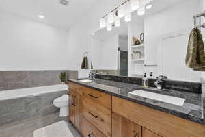 Full bathroom with double vanity, a garden tub, and a stall shower