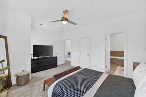Bedroom with a ceiling fan, ensuite bath, and carpet