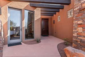 View of exterior entry featuring stucco siding and stone siding