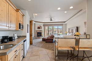 Kitchen featuring open floor plan, light brown cabinets, a fireplace, and recessed lighting