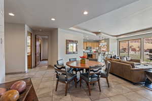 Dining area featuring recessed lighting, a raised ceiling, light tile patterned floors, and plenty of natural light