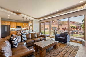 Living area with a tray ceiling, recessed lighting, and a mountain view