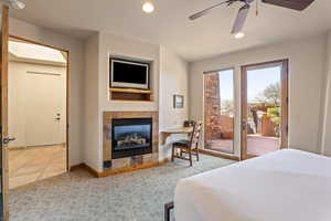 Carpeted bedroom with access to outside, a fireplace, recessed lighting, a ceiling fan, and tile patterned flooring