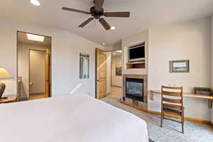 Bedroom featuring a tiled fireplace, recessed lighting, and ceiling fan