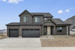 View of front of property with a mountain view, board and batten siding, and roof with shingles
