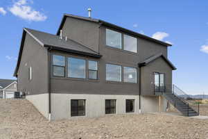 Back of property featuring stucco siding and stairway
