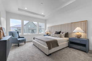 Bedroom with carpet floors, a tray ceiling, and recessed lighting
