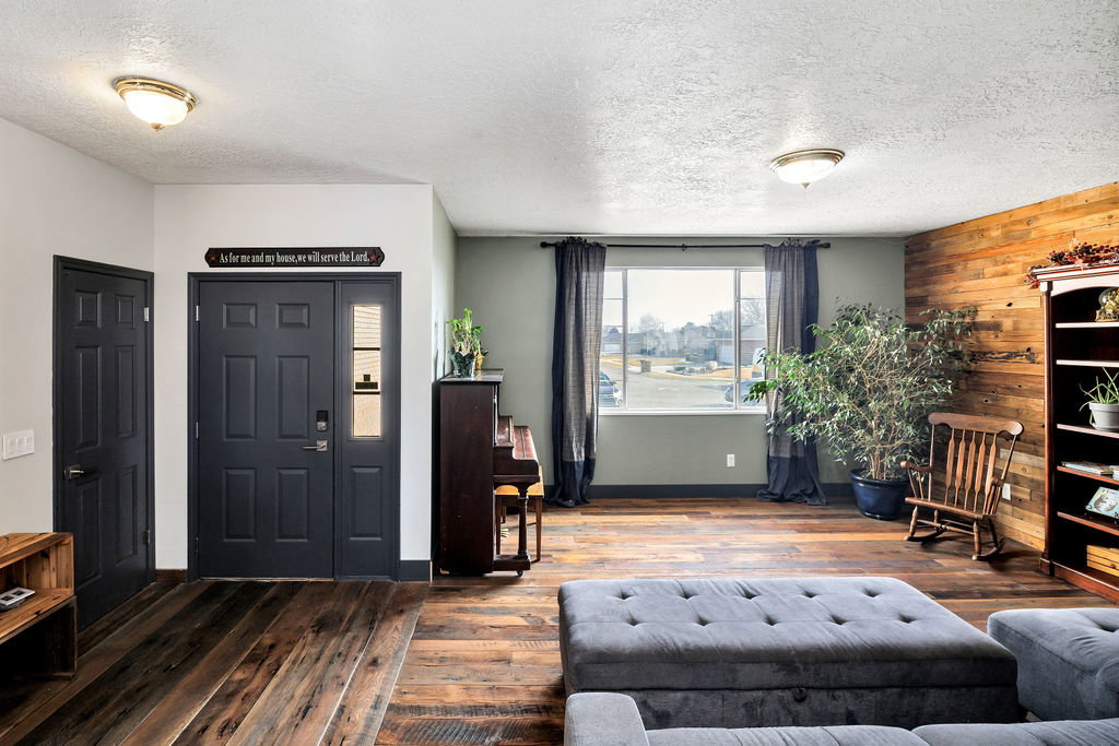 Foyer with hardwood / wood-style flooring, a textured ceiling, and wood walls