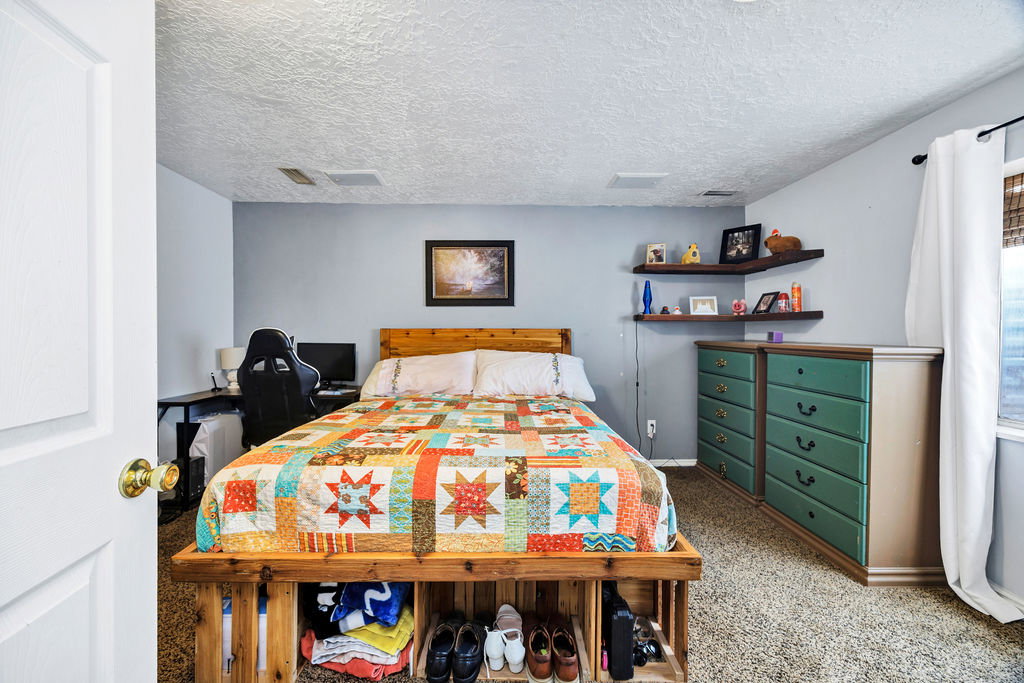 Carpeted bedroom featuring a textured ceiling