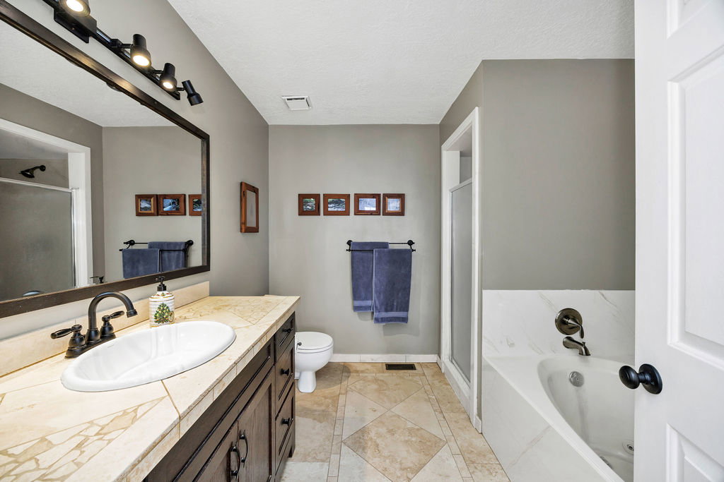 Bathroom featuring a stall shower, vanity, a garden tub, light tile patterned floors, and a textured ceiling
