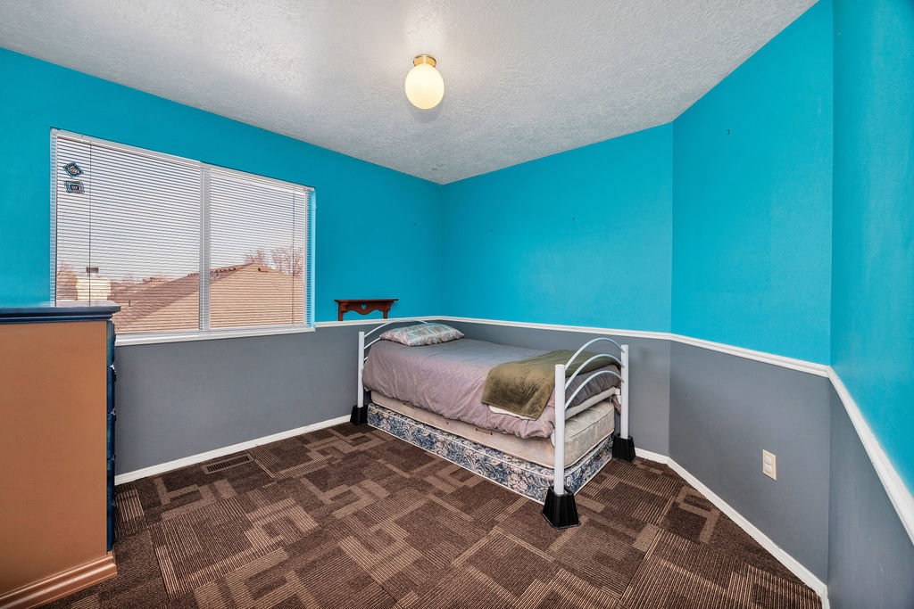 Bedroom with dark carpet and a textured ceiling