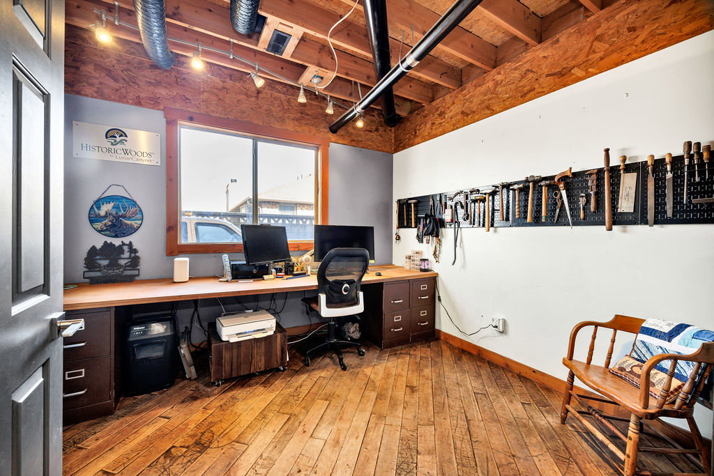 Office space featuring light wood-type flooring and track lighting