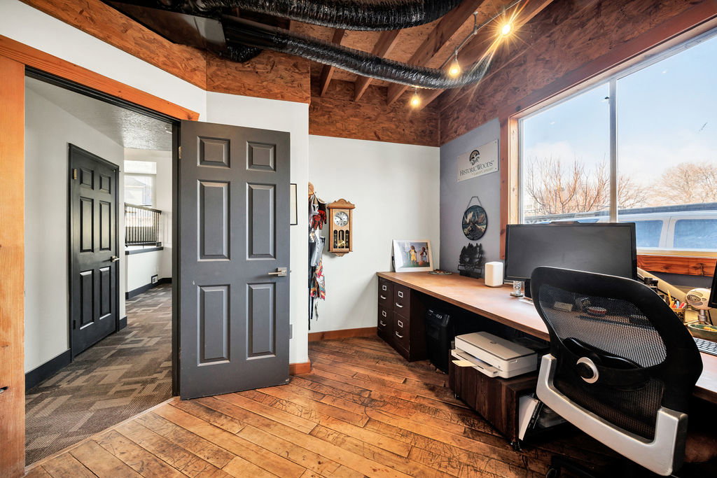 Office area featuring dark wood-style floors and baseboards