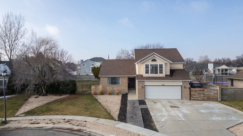 Traditional-style home featuring roof with shingles, concrete driveway, and a residential view