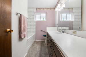 Full  main level bath featuring vanity, dark carpet, and tub / shower combination
