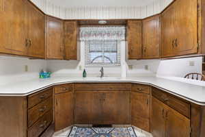 Kitchen featuring light countertops, brown cabinets, and a peninsula