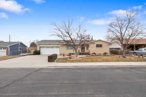 Ranch-style house featuring concrete driveway, a garage, and brick siding