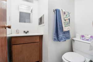 Basement half bath with vanity and toilet
