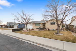 Ranch-style home with brick siding, concrete driveway, a chimney, and an attached garage