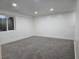 Empty room with carpet flooring and recessed lighting